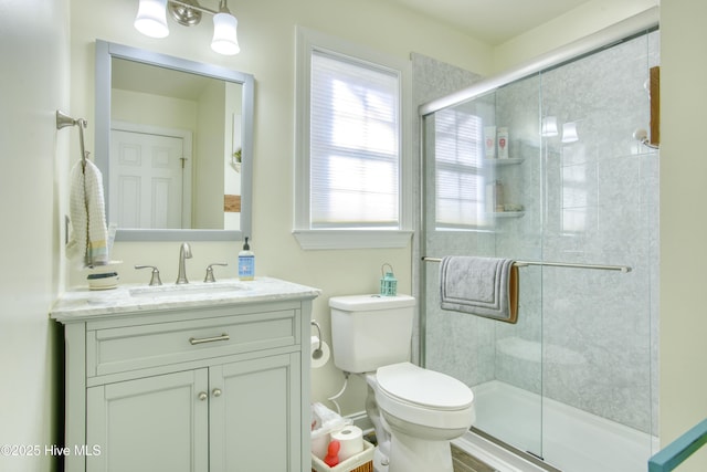 bathroom with toilet, walk in shower, and vanity