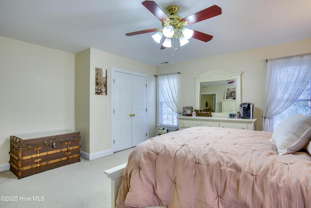 carpeted bedroom featuring ceiling fan, a closet, and multiple windows