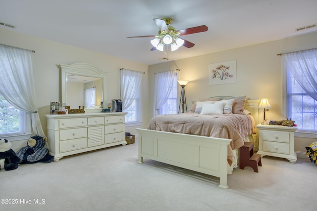 carpeted bedroom with ceiling fan and multiple windows