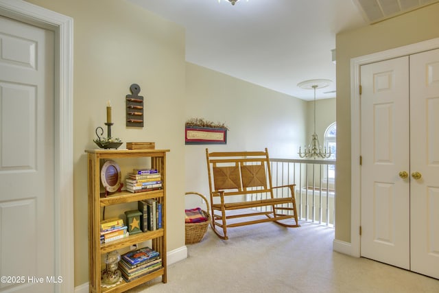 hallway with light carpet and a notable chandelier