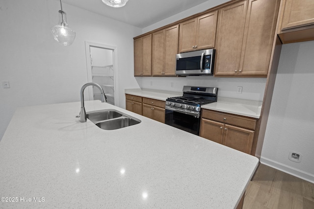 kitchen featuring hanging light fixtures, appliances with stainless steel finishes, sink, and dark hardwood / wood-style flooring