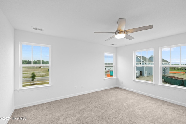 carpeted spare room with ceiling fan