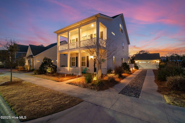 view of front of property with an outbuilding, a balcony, a porch, and a garage