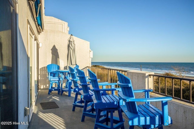 balcony with a water view and a beach view