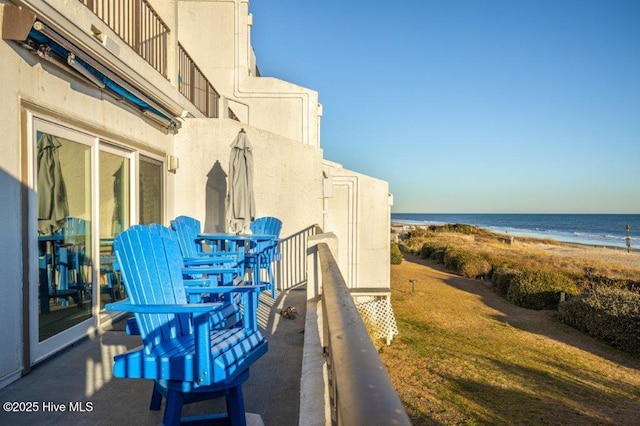 balcony featuring a water view and a view of the beach