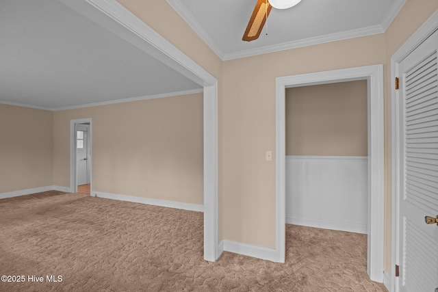 interior space with ceiling fan, light carpet, and crown molding