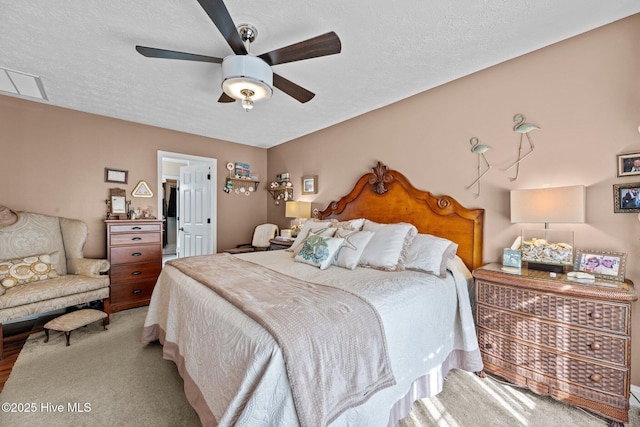 bedroom with ceiling fan and a textured ceiling