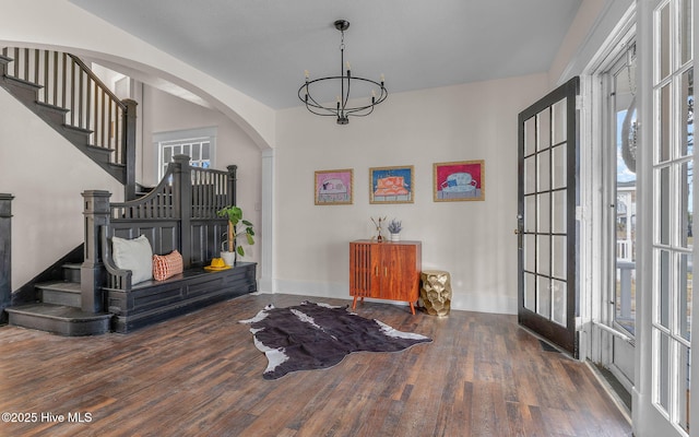 foyer entrance featuring french doors, dark wood-type flooring, and a chandelier