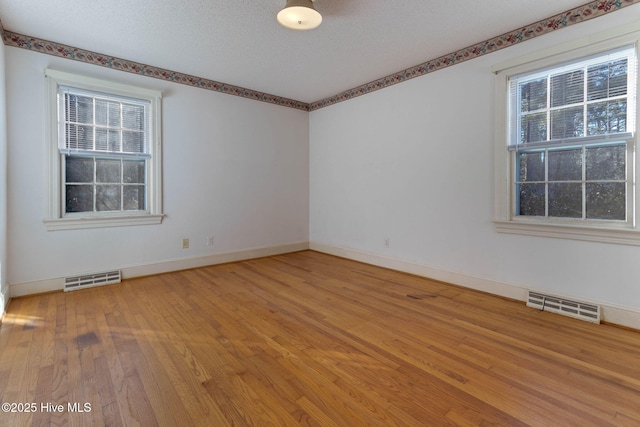 unfurnished room featuring a textured ceiling and hardwood / wood-style flooring