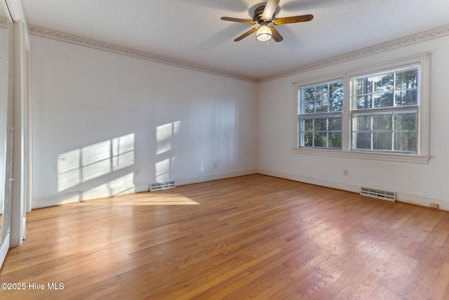 spare room with a textured ceiling, ceiling fan, and light hardwood / wood-style floors