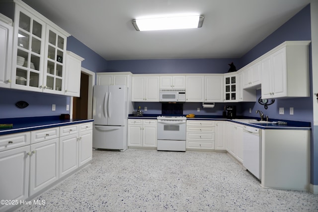 kitchen featuring sink, white appliances, and white cabinetry