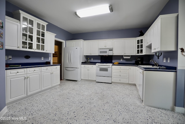 kitchen featuring white cabinetry, sink, and white appliances