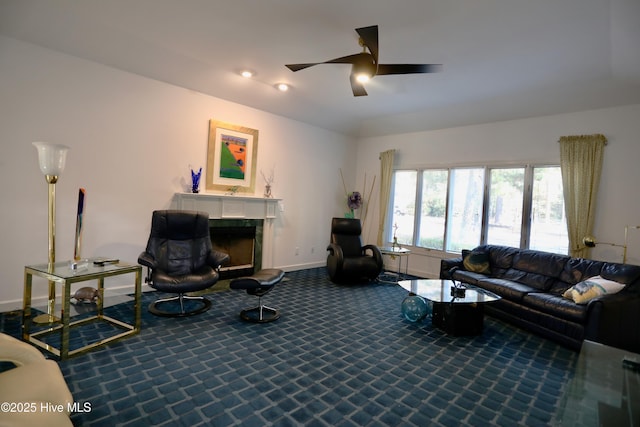 carpeted living room featuring ceiling fan and a fireplace