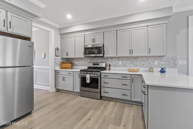 kitchen featuring stainless steel appliances, gray cabinetry, and ornamental molding