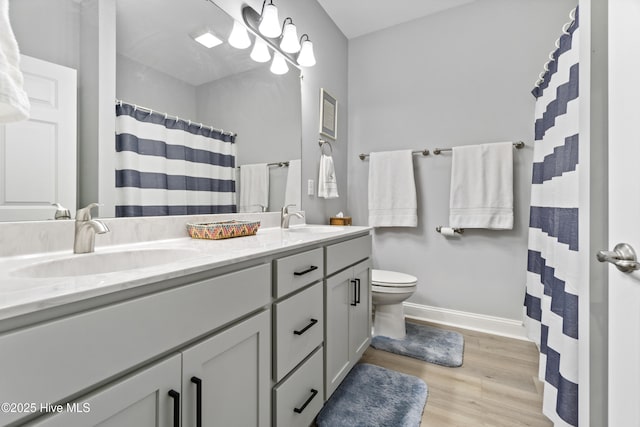 bathroom with hardwood / wood-style flooring, toilet, vanity, and a shower with shower curtain