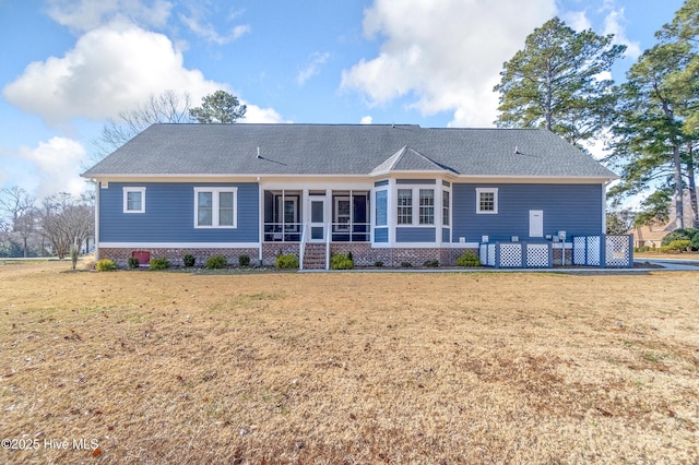 rear view of property featuring a sunroom and a lawn