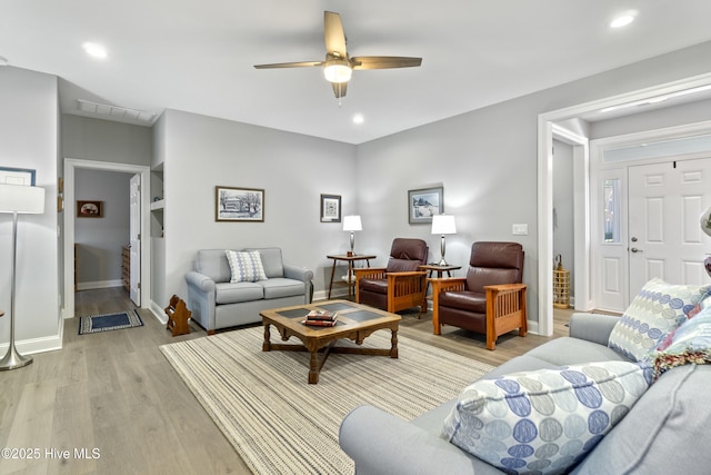 living room featuring ceiling fan and light hardwood / wood-style flooring