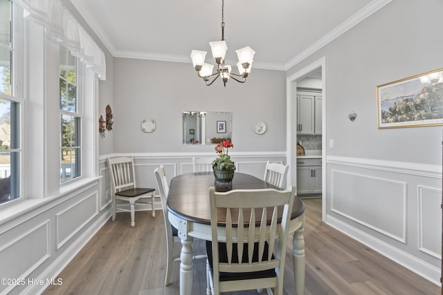 dining area with hardwood / wood-style flooring, plenty of natural light, and crown molding