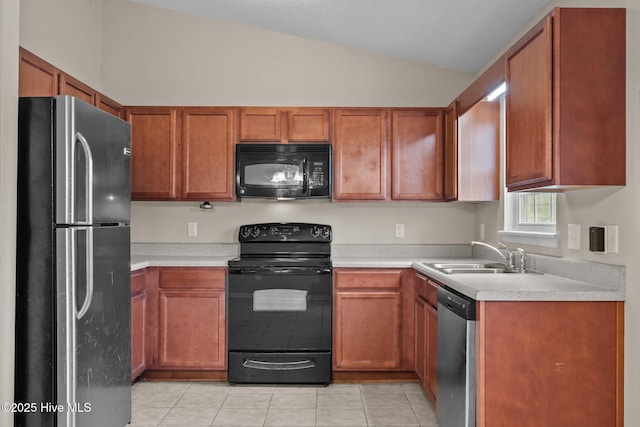 kitchen featuring lofted ceiling, light tile patterned floors, a sink, light countertops, and black appliances