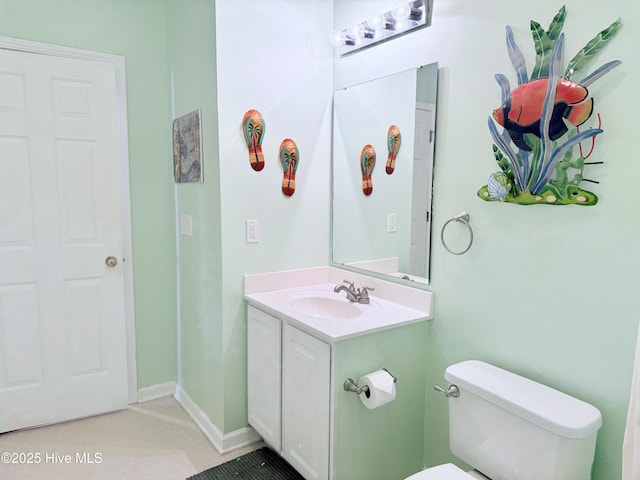 bathroom featuring baseboards, toilet, and vanity