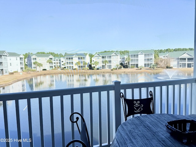 balcony with a residential view and a water view