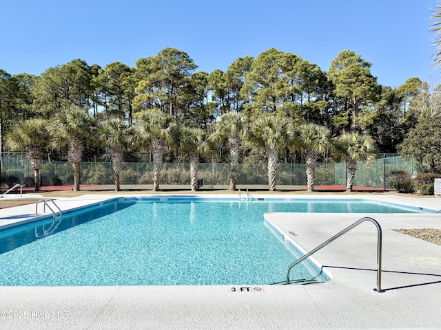 pool with a patio area and fence