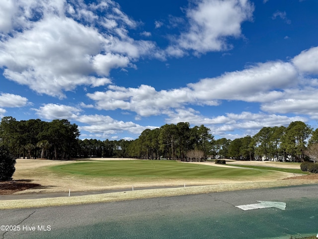 surrounding community featuring a lawn and view of golf course