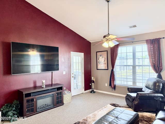 living room with lofted ceiling, ceiling fan, and carpet flooring