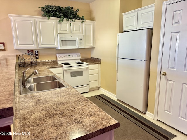 kitchen featuring a sink, baseboards, white appliances, and white cabinetry