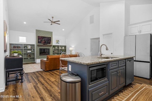 kitchen with electric range, a sink, white cabinets, wall chimney exhaust hood, and tasteful backsplash