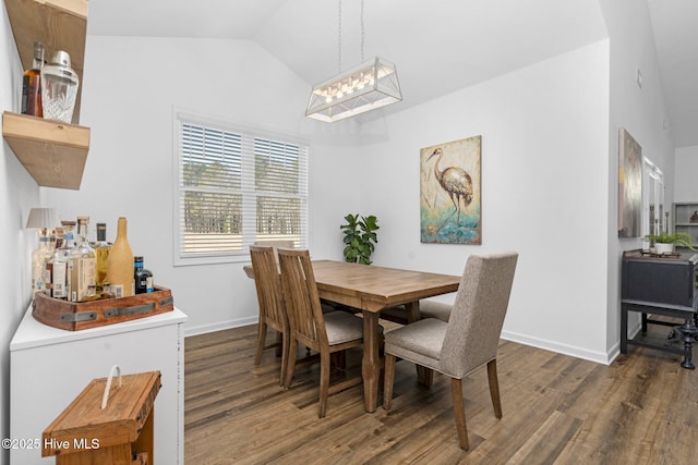 dining space featuring vaulted ceiling, baseboards, and wood finished floors