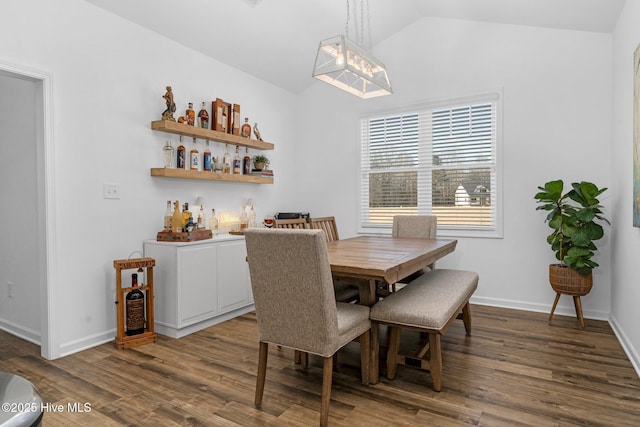 dining area with vaulted ceiling, wood finished floors, and baseboards