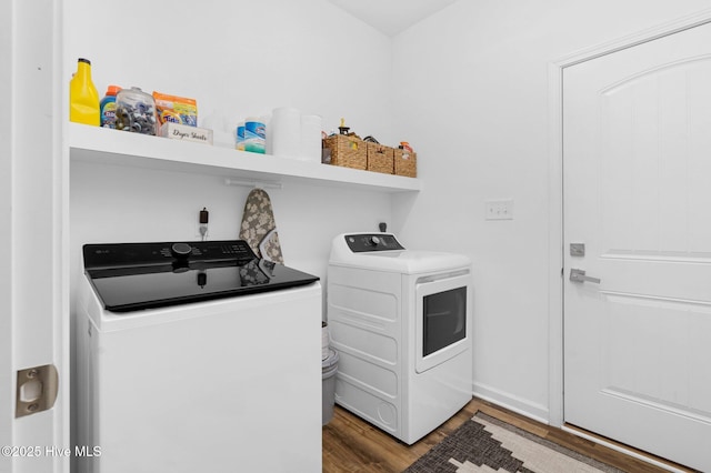 clothes washing area with washing machine and dryer, laundry area, and wood finished floors