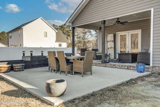 view of patio featuring ceiling fan, french doors, outdoor dining space, and fence