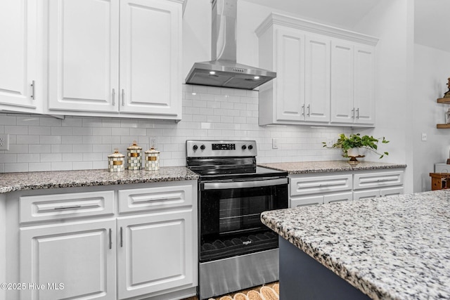 kitchen featuring light stone counters, tasteful backsplash, white cabinets, stainless steel range with electric cooktop, and wall chimney exhaust hood