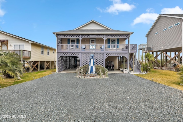 beach home featuring covered porch, a front lawn, and a carport