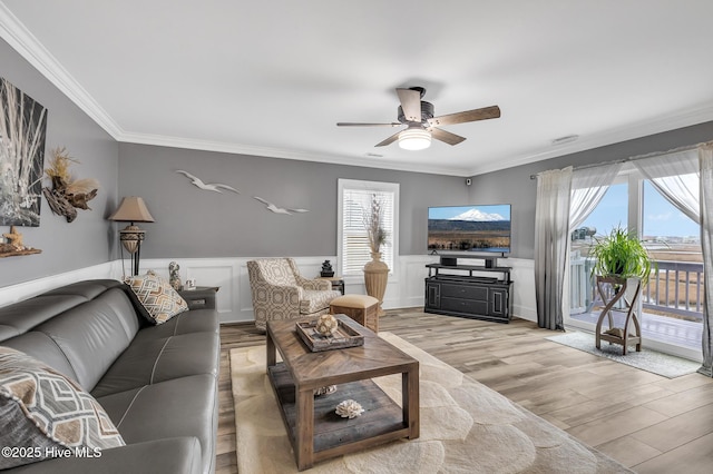 living room featuring ceiling fan, crown molding, and light hardwood / wood-style floors