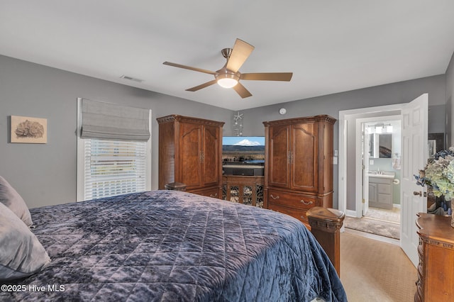 bedroom with ceiling fan, light colored carpet, connected bathroom, and sink