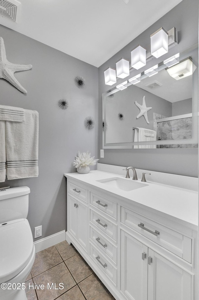 bathroom featuring toilet, vanity, tile patterned floors, and walk in shower