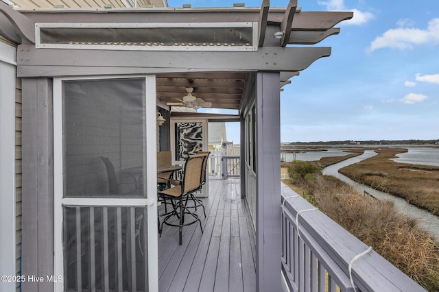 wooden deck featuring ceiling fan and a water view