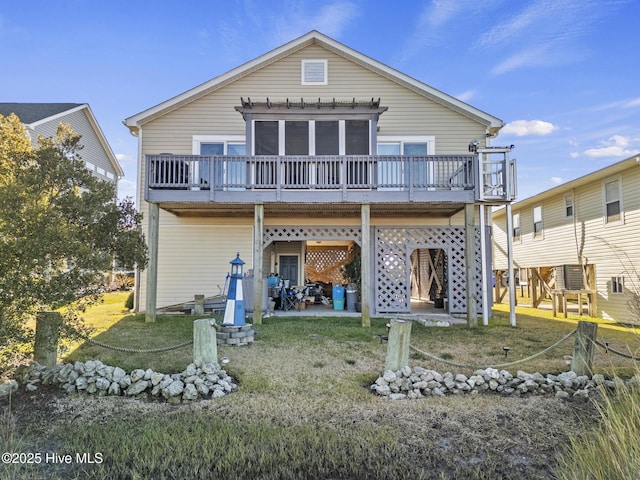 back of house featuring a wooden deck, a sunroom, and a yard