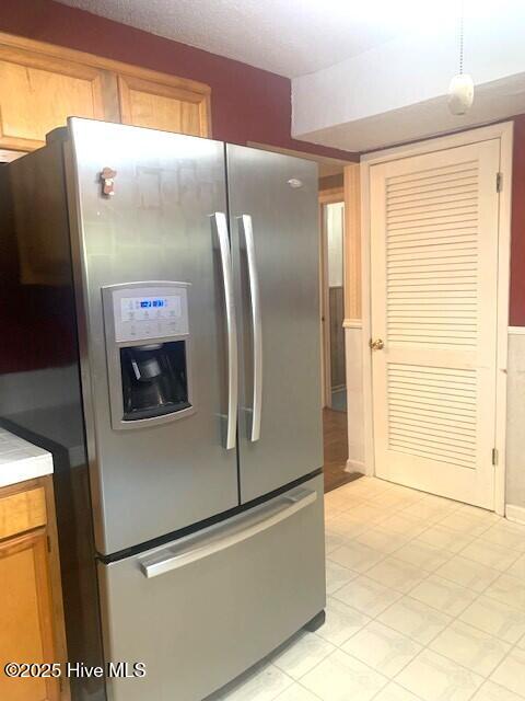 kitchen with stainless steel refrigerator with ice dispenser and pendant lighting