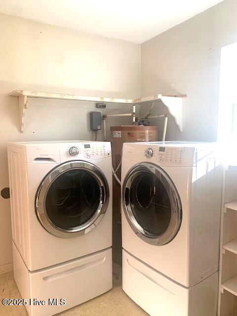 laundry area with light tile patterned floors and washing machine and clothes dryer