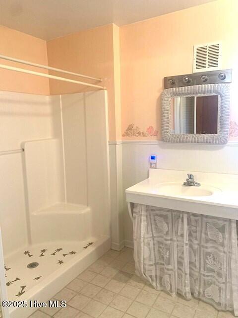 bathroom featuring tile patterned flooring, walk in shower, and sink