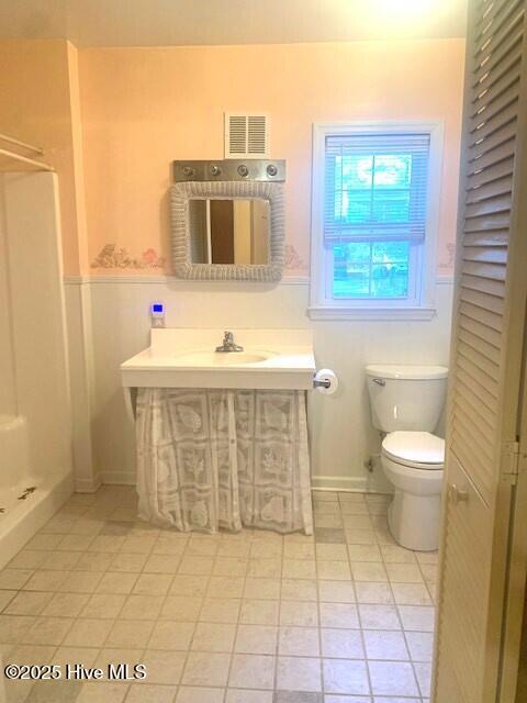 bathroom with toilet, tile patterned flooring, walk in shower, and vanity