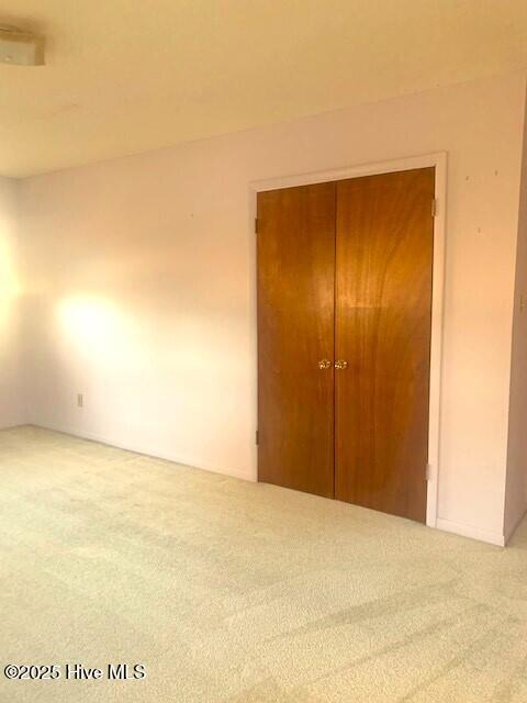 unfurnished bedroom with a closet and carpet flooring