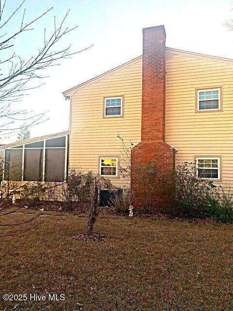 view of home's exterior with a sunroom