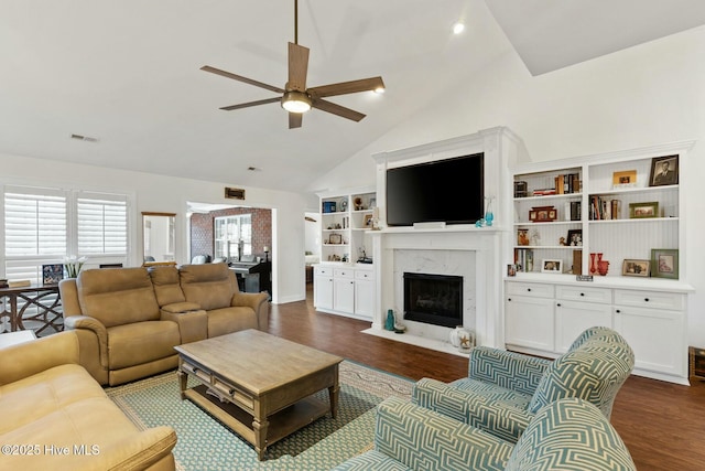 living room with a premium fireplace, high vaulted ceiling, dark wood-type flooring, and ceiling fan