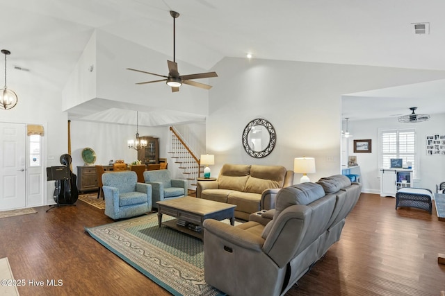 living room featuring dark hardwood / wood-style floors, ceiling fan with notable chandelier, and high vaulted ceiling