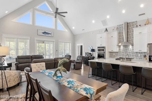 dining space featuring high vaulted ceiling, dark wood-type flooring, and ceiling fan